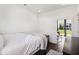Simple bedroom featuring a light gray blanket, natural light from a window, and dark wood floors at 318 Ripple Park Dr, Summerville, SC 29486