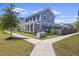 Charming blue two-story home featuring a welcoming front porch and well-manicured lawn in a sidewalk neighborhood at 318 Ripple Park Dr, Summerville, SC 29486