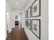 Hallway with wood floors and framed photos leading to an open living area at 318 Ripple Park Dr, Summerville, SC 29486