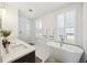 Bright main bathroom featuring a modern tub, dual vanity, and large windows offering natural light at 318 Ripple Park Dr, Summerville, SC 29486