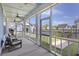 Relaxing screened-in porch with seating and a view of the landscaped backyard at 318 Ripple Park Dr, Summerville, SC 29486