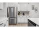 Kitchen featuring stainless steel refrigerator, white cabinetry, hardwood floors, and decorative backsplash at 326 Surfbird Rd # 388, Summerville, SC 29486