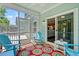 Relaxing screened porch with blue chairs and view of lush backyard at 3751 Copahee Sound Dr, Mount Pleasant, SC 29466