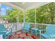 Cozy screened porch featuring cheerful blue Adirondack chairs and a colorful floral rug at 3751 Copahee Sound Dr, Mount Pleasant, SC 29466