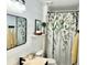 Stylish bathroom with shiplap walls, dark fixtures, vanity and decorative shower curtain at 3784 Scotts Mill Dr, North Charleston, SC 29420