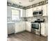 Bright kitchen features white cabinets, stainless steel appliances, and wood floors at 3784 Scotts Mill Dr, North Charleston, SC 29420