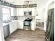 Beautifully updated kitchen with white cabinets, stainless steel appliances, subway tile backsplash, and gray plank flooring at 3784 Scotts Mill Dr, North Charleston, SC 29420