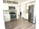 Bright, remodeled kitchen featuring white cabinets, stainless steel appliances, and modern gray plank flooring at 3784 Scotts Mill Dr, North Charleston, SC 29420
