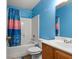 Vibrant bathroom with a shower-tub combination, modern vanity, and cheerful blue walls at 402 Equinox Cir, Ladson, SC 29456