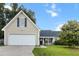 Inviting tan home with a spacious two-car garage, green shutters, and a well-manicured front yard at 402 Equinox Cir, Ladson, SC 29456