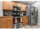 Efficient kitchen space with stainless steel appliances, wooden cabinets, and a view into the dining area at 402 Equinox Cir, Ladson, SC 29456