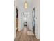 Bright hallway features hardwood floors, modern light fixture, and open doorways leading to inviting spaces at 4114 Maidstone Dr, Mount Pleasant, SC 29466