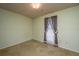 Empty bedroom featuring light green walls, wall-to-wall carpeting and a window with brown floral curtains at 4328 Cheviot Dr, North Charleston, SC 29418