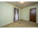 Empty bedroom with doorway and window with patterned curtains and tan carpet at 4328 Cheviot Dr, North Charleston, SC 29418