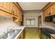 Eat in kitchen with a stainless steel sink, wood cabinets and green and yellow floor tiles at 4328 Cheviot Dr, North Charleston, SC 29418