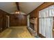 Living room with wood paneling, a brick fireplace, carpeted floors, and natural light at 4328 Cheviot Dr, North Charleston, SC 29418