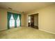 Spacious living room features a vintage chandelier, doorway to foyer, and large bright windows with teal curtains at 4328 Cheviot Dr, North Charleston, SC 29418