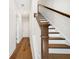 Hallway with hardwood floors leading to a carpeted staircase and white trim at 4404 Avery Ave, North Charleston, SC 29405