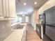 Kitchen view with stone-look counters, stainless steel sink, black appliances, and an open floorplan concept at 4818 Holly Berry Ln, Summerville, SC 29485