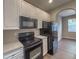 The kitchen features white cabinets with black appliances and stone-look countertops at 4818 Holly Berry Ln, Summerville, SC 29485