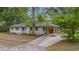 Single-story white brick home featuring an attached carport, mature trees, and well-maintained landscaping at 4924 France Ave, North Charleston, SC 29405