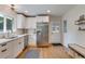 Well-lit kitchen boasts white cabinets, stainless steel appliances, wood floors, and backyard access at 4924 France Ave, North Charleston, SC 29405
