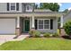 Inviting front porch with white pillars, brick accents, and a well-maintained garden at 4977 Ballantine Dr, Summerville, SC 29485