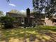 Brick home exterior featuring a chimney and backyard with green grass and trees at 5 Apple Cir, Goose Creek, SC 29445