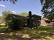 Brick home exterior featuring a chimney and backyard with green grass and trees at 5 Apple Cir, Goose Creek, SC 29445