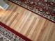A high-angle view showing wood flooring bordered by the edge of a red oriental rug at 5 Apple Cir, Goose Creek, SC 29445