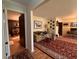 Features a living room with a patterned red rug, hardwood floors, and a view into another room with a fireplace at 5 Apple Cir, Goose Creek, SC 29445