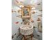 Powder room with unique fish-themed wallpaper, marble sink, and gold accents at 5 Legare St # C, Charleston, SC 29401