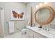 Well-lit bathroom with decorative round mirror and unique butterfly artwork at 5 Legare St # C, Charleston, SC 29401
