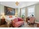 Spacious bedroom with a red sofa, a large tiger artwork, and two bright windows at 5 Legare St # C, Charleston, SC 29401