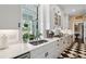 Bright kitchen features a black and white checkered floor, marble countertops, and white cabinets with blue hardware at 5 Legare St # C, Charleston, SC 29401