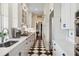 Galley kitchen with black and white checkered floor, marble countertops, and white cabinets with blue hardware at 5 Legare St # C, Charleston, SC 29401