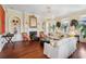 Bright living room with hardwood floors, chandelier, fireplace, and white sofas near several windows at 5 Legare St # C, Charleston, SC 29401