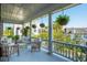 Covered porch with outdoor seating, white columns, and hanging fern plants at 5 Legare St # C, Charleston, SC 29401