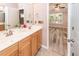 Bathroom featuring a double sink vanity, neutral tile flooring and a doorway leading to the bedroom at 5002 W Liberty Meadows Dr, Summerville, SC 29485