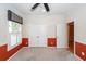 Bedroom featuring carpet, red accent wall, and white double doors and a window with patterned roman shades at 5002 W Liberty Meadows Dr, Summerville, SC 29485