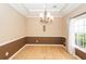 The formal dining room has a decorative chandelier and a large window for natural light at 5002 W Liberty Meadows Dr, Summerville, SC 29485
