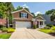 Charming two-story home featuring a brick facade, attached garage, and well-manicured front yard at 5002 W Liberty Meadows Dr, Summerville, SC 29485