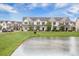 Scenic community pond surrounded by well-kept townhomes, lush green grass, and beautiful sky at 502 Duskywing Dr, Goose Creek, SC 29445