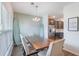 Bright dining area with modern chandelier, decorative surfboards and hardwood table adjacent to the kitchen at 502 Duskywing Dr, Goose Creek, SC 29445