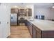 Well-equipped kitchen with stainless steel appliances, modern cabinetry and countertop bar overlooking the living room at 502 Duskywing Dr, Goose Creek, SC 29445