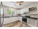 Well-lit kitchen with white cabinetry, black countertops, and stainless steel appliances at 5052 Hidden Forest Ln, North Charleston, SC 29420
