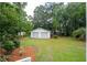 Detached two-car garage stands in the well-manicured lawn of the backyard at 521 Carpenter St, Charleston, SC 29412