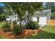 View of the backyard featuring the home's back porch, side door, lawn, and landscaping at 521 Carpenter St, Charleston, SC 29412