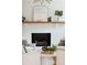 Close up of a white brick fireplace with a wood mantle and decorative accents at 521 Carpenter St, Charleston, SC 29412