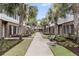 Townhome lined walkway featuring well-maintained lawns, palm trees, and seating areas at 656 Coleman Blvd # 703, Mount Pleasant, SC 29464